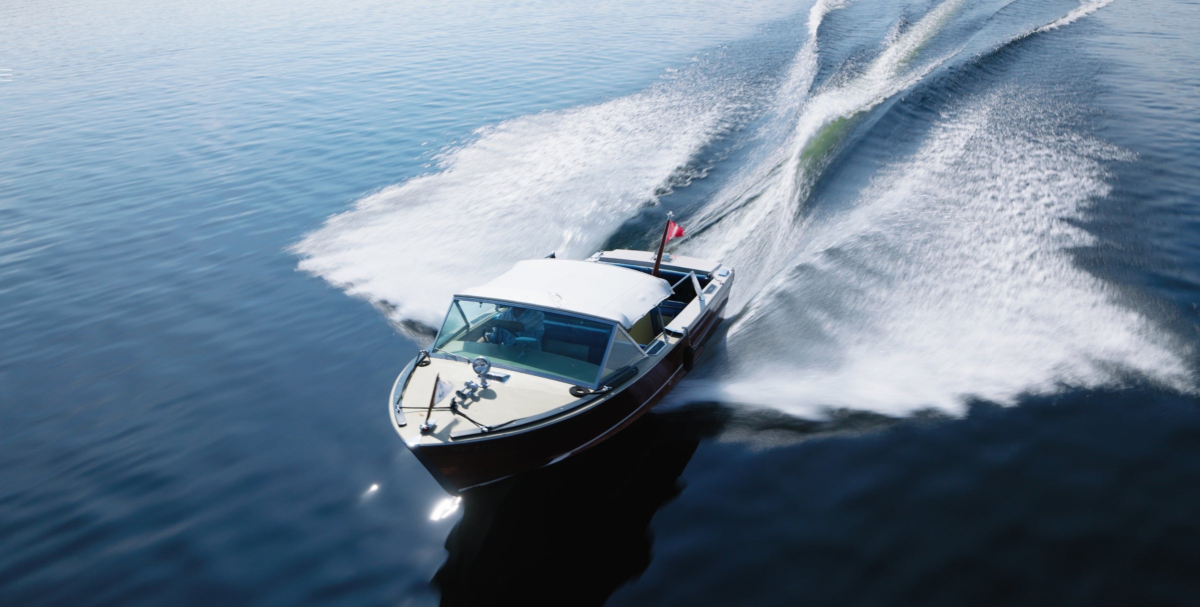 Speedboat leaving a trail of water on a calm lake