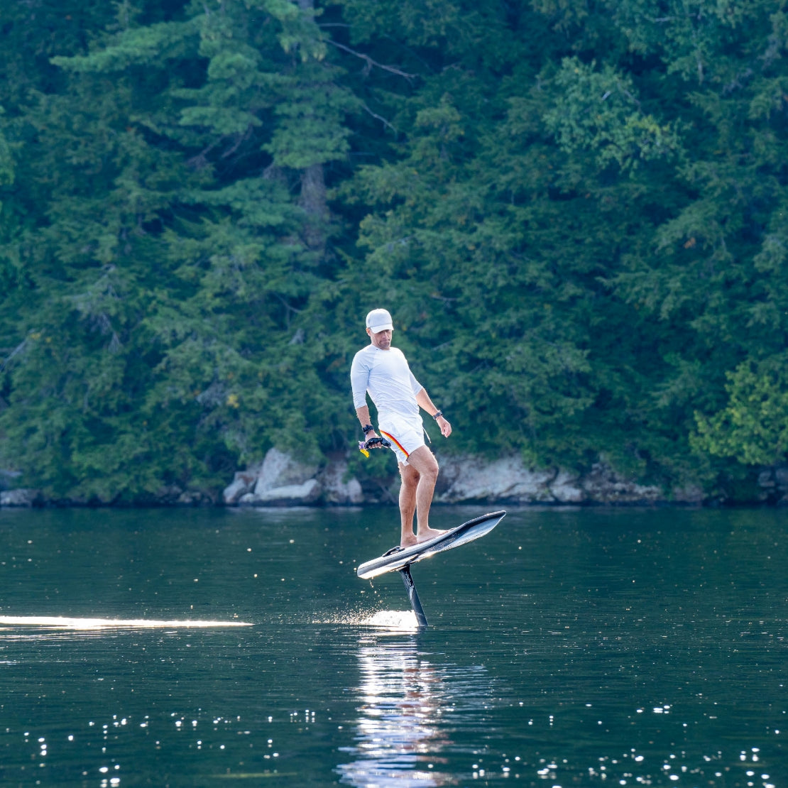 Person on a hoverboard in a lake with trees in the background