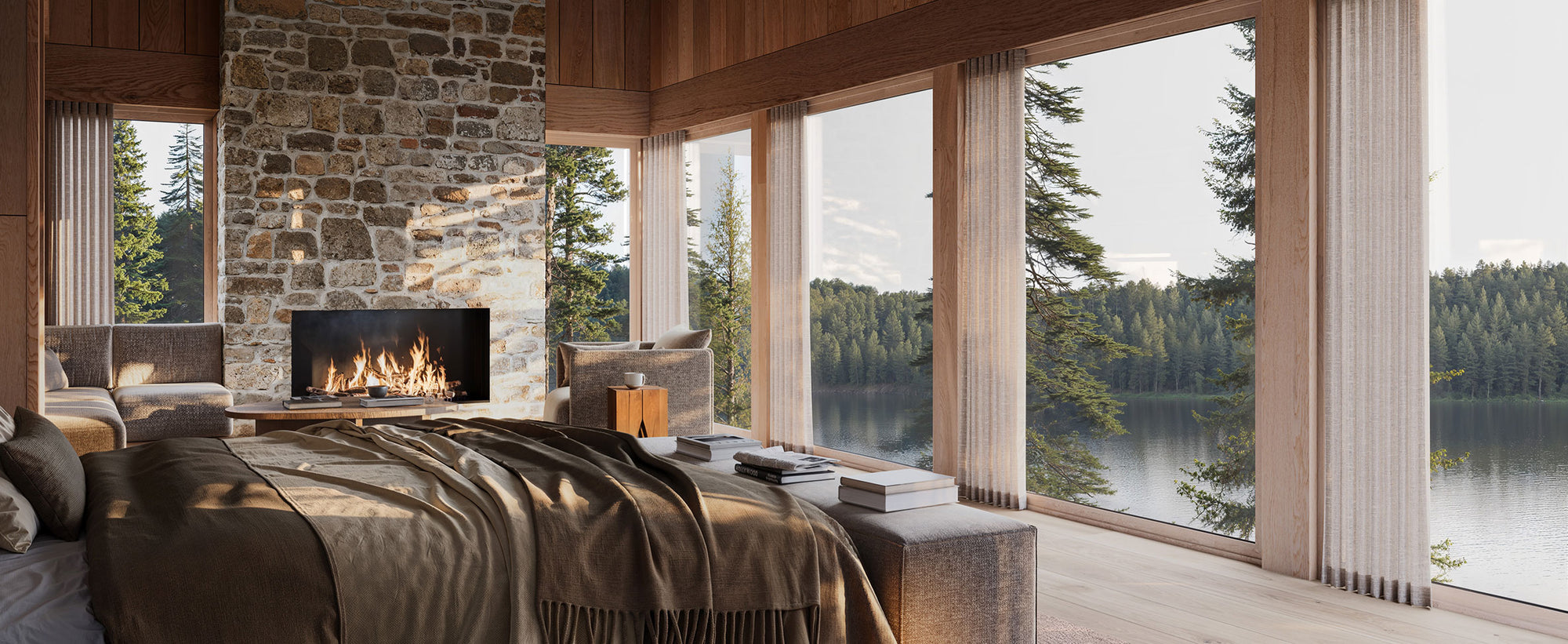 Modern bedroom with stone fireplace and large windows overlooking a lake and forest